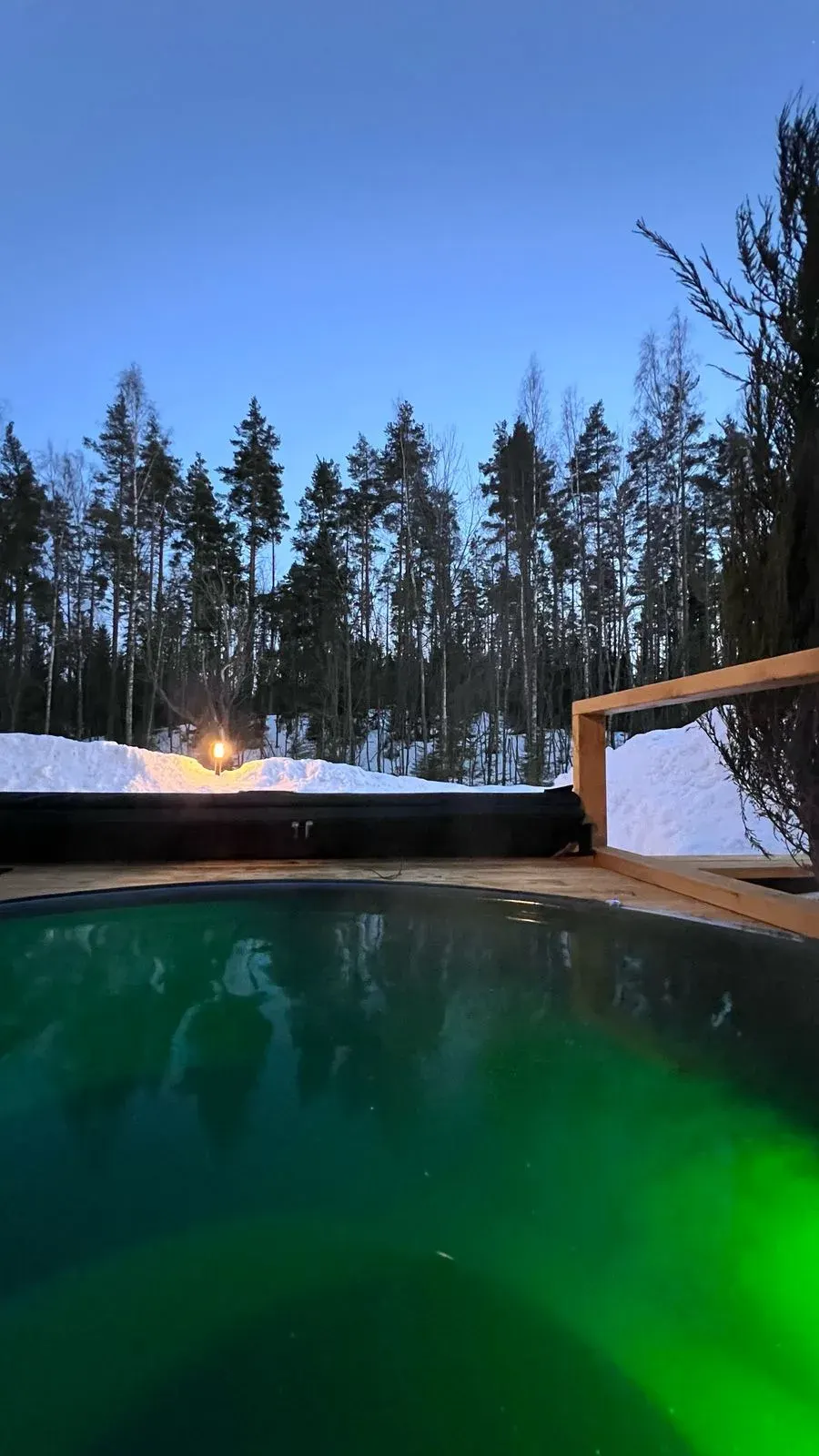 Зелёная подсветка воды в купели ГоркиБарн зимним вечером